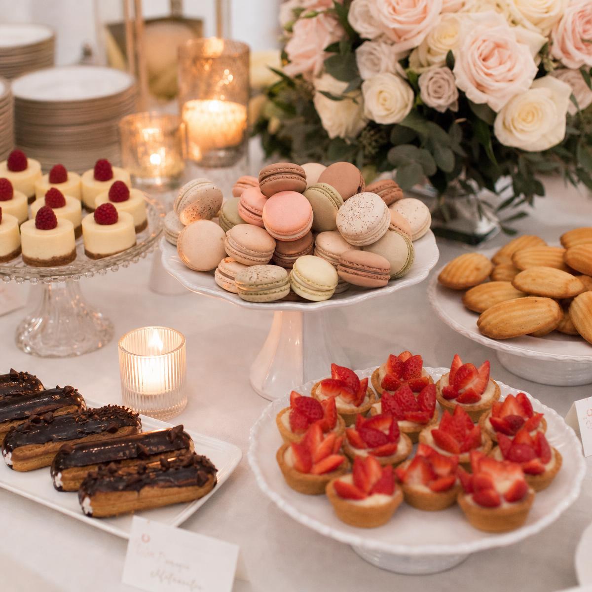 Wedding dessert display with macarons, strawberry tarts, éclairs and mini cheesecakes
